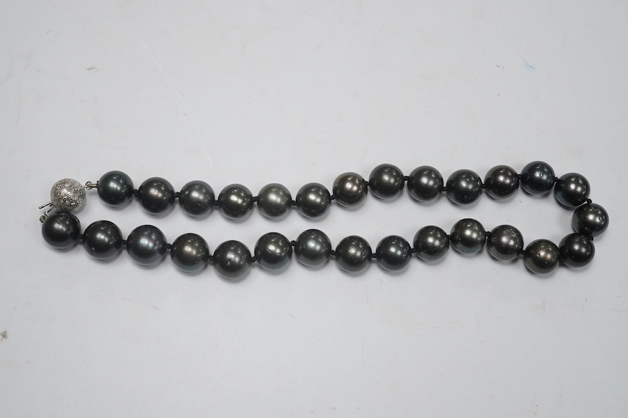 A modern single strand Tahitian black pearl necklace, with diamond cluster set 14k white metal spherical clasp, 40cm. Condition - fair to good